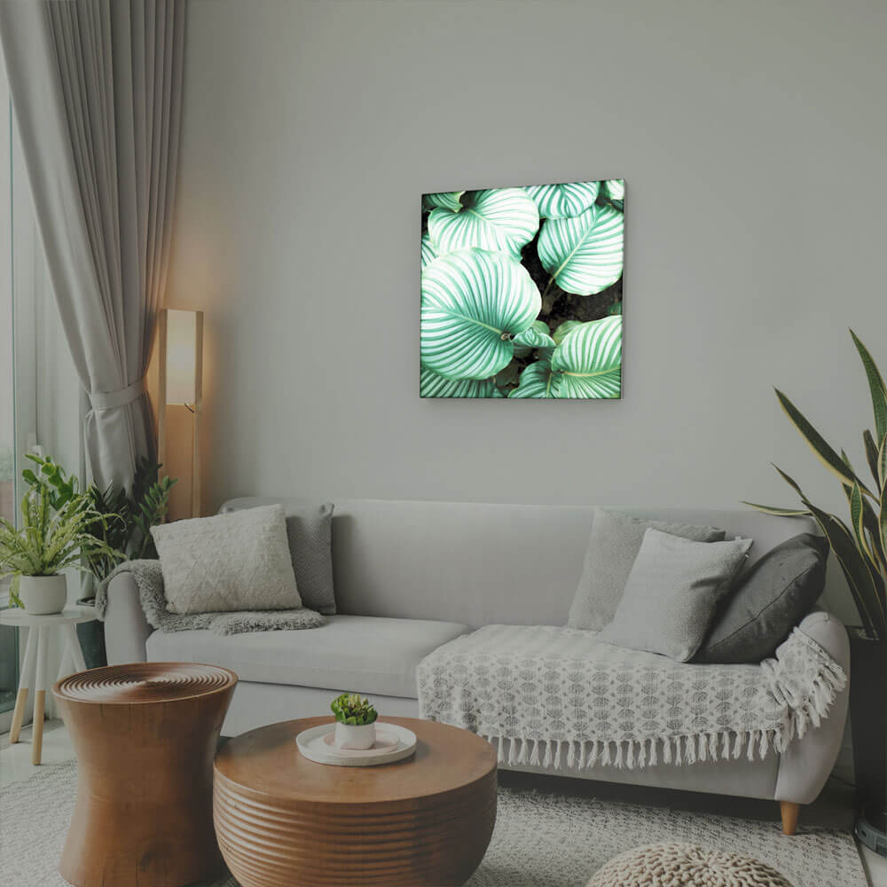 Wohnzimmer mit Couch, Tisch und Pflanzen, an Wand Pixlip Poster mit Textildruck